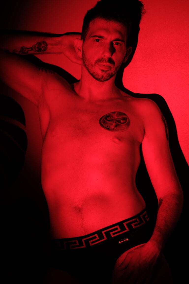 Portrait masculin de face éclairé en rouge, en sous-vêtements