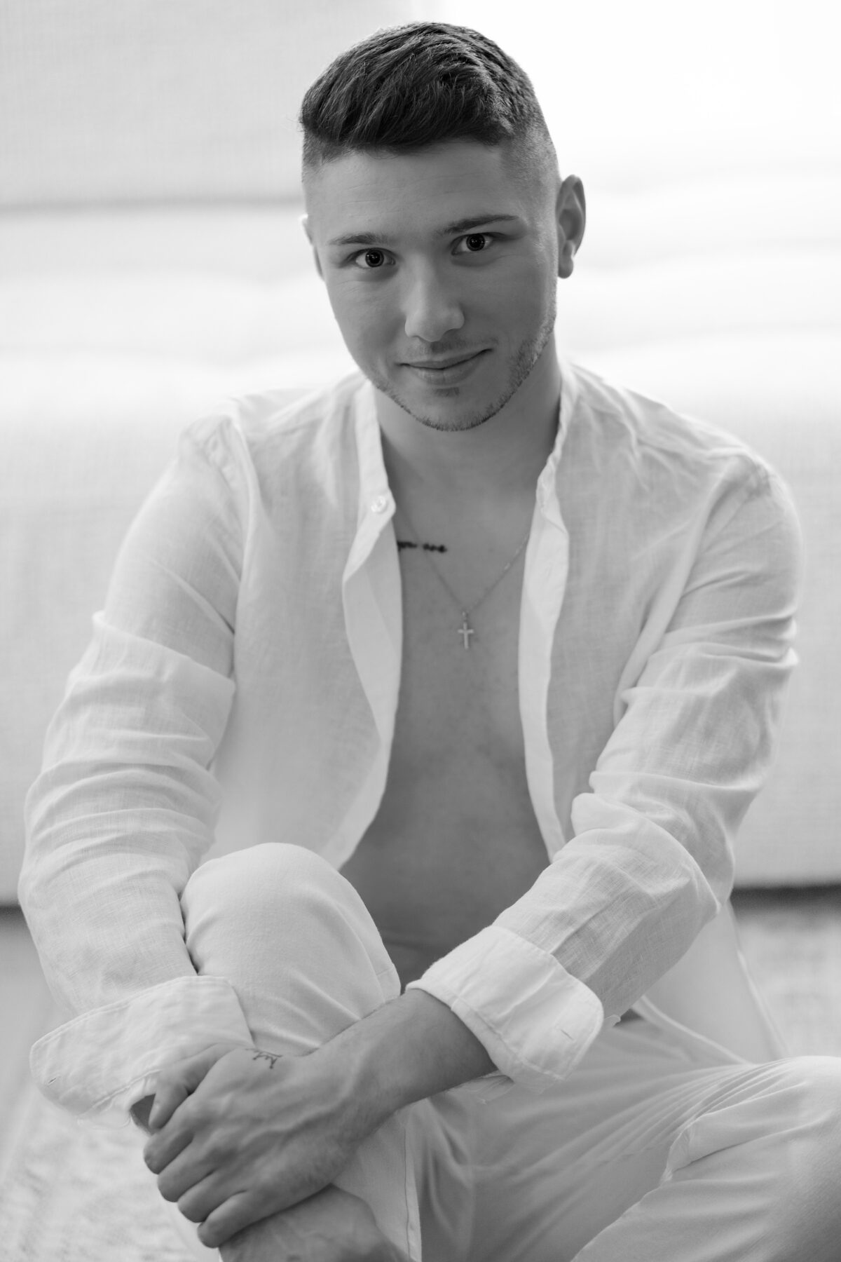 Portrait assis de William en tenue blanche, torse entrouvert, noir et blanc