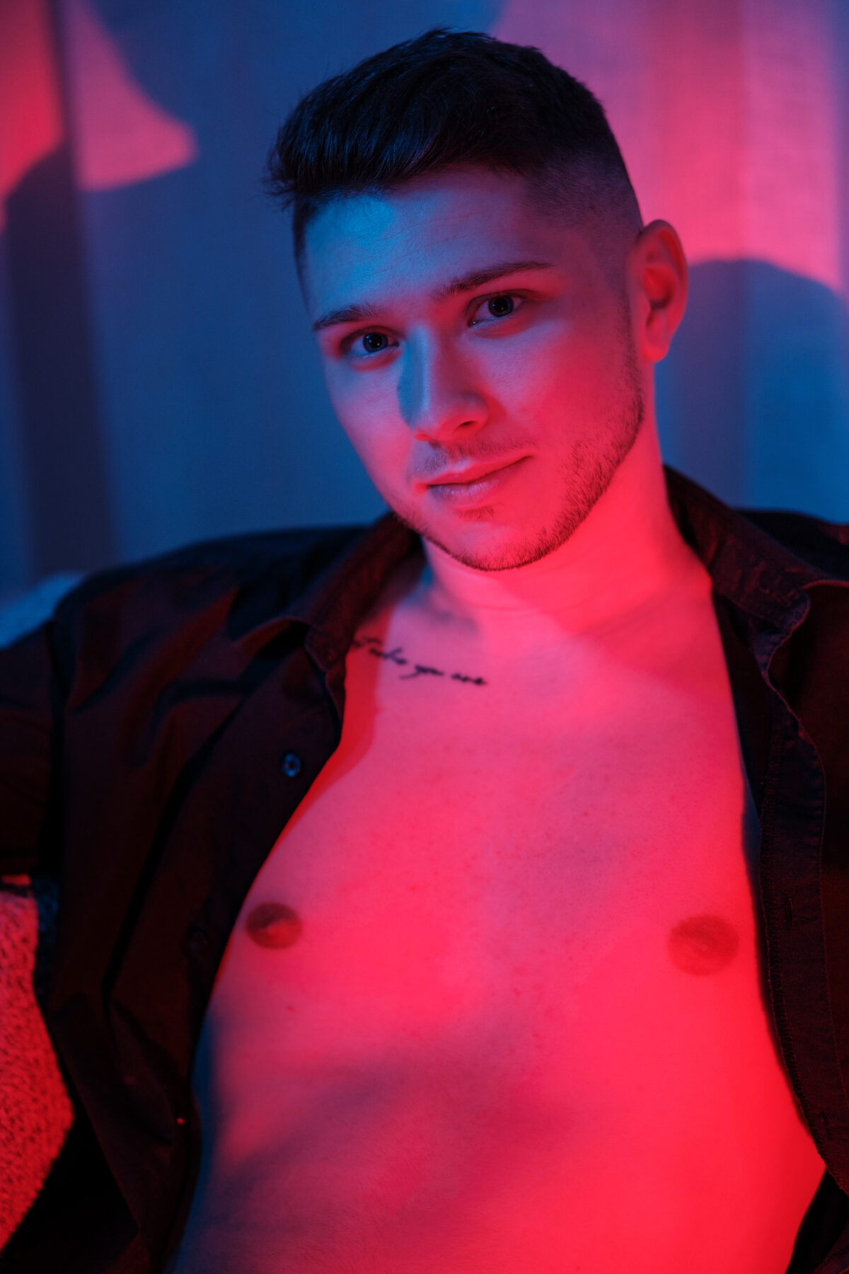 Portrait torse nu de William, chemise ouverte, éclairage rouge intense