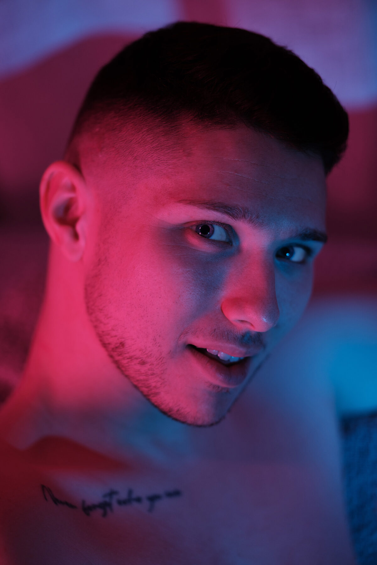 Portrait rapproché de William, torse nu, éclairage bicolore rouge et bleu