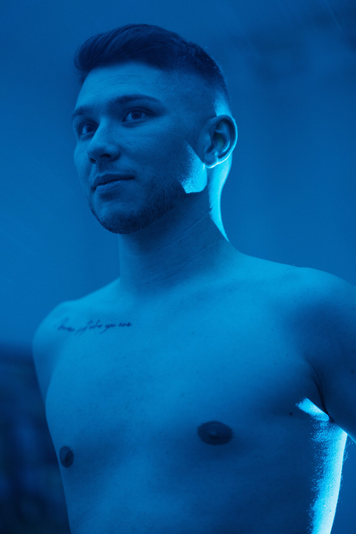 Portrait torse nu de William, regard au loin, ambiance bleu profond
