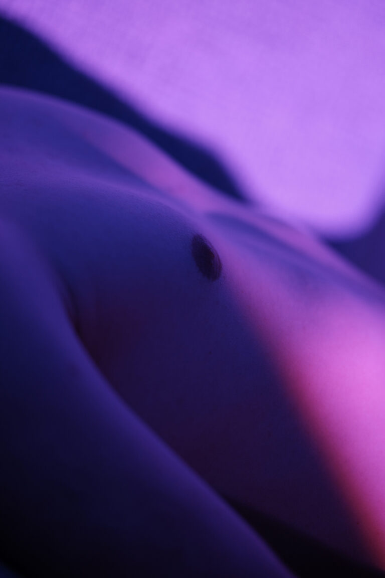 Gros plan abstrait sur le torse de William, éclairage violet