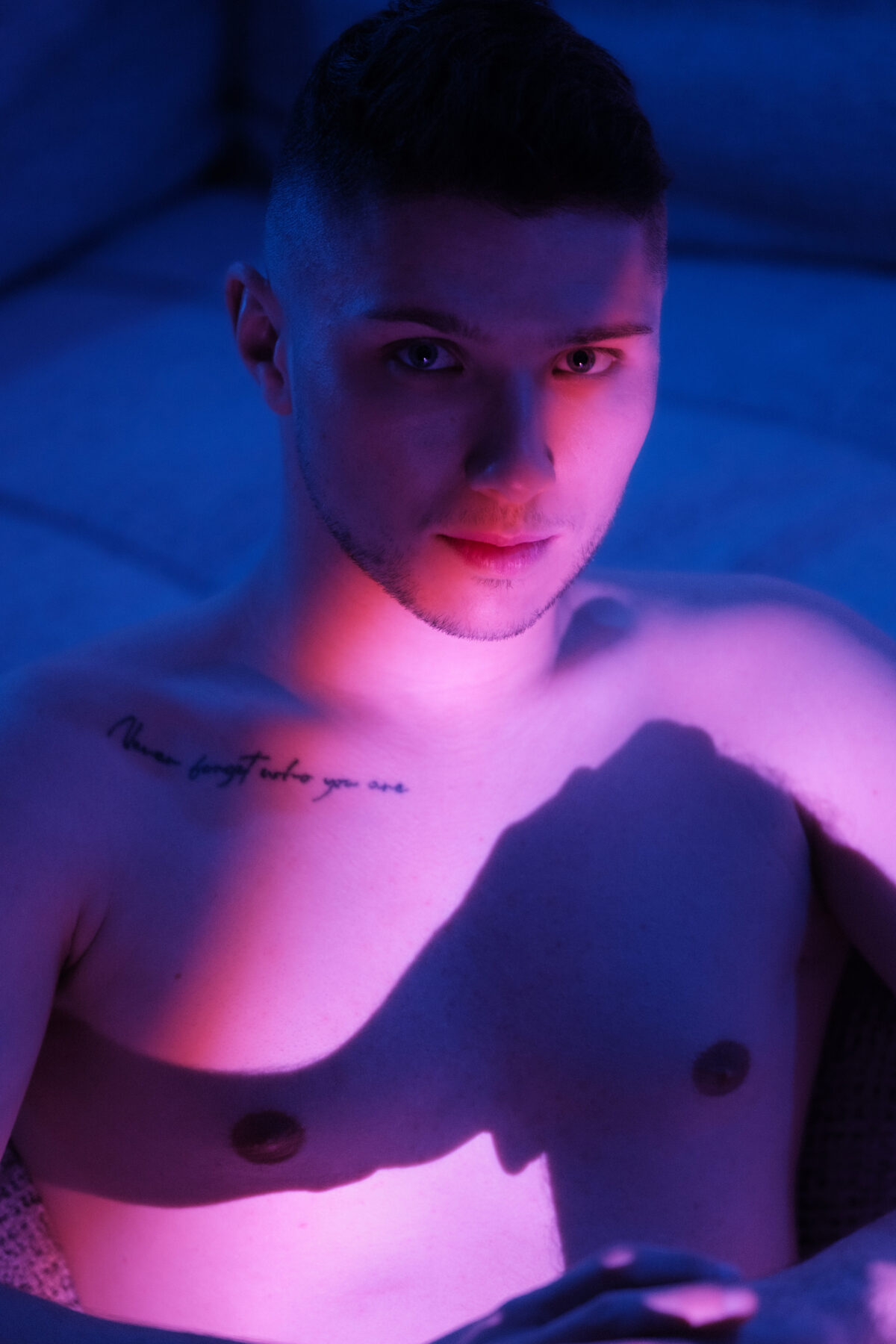 Portrait torse nu de William, jeu d'ombre sur le buste, éclairage bleu et rose
