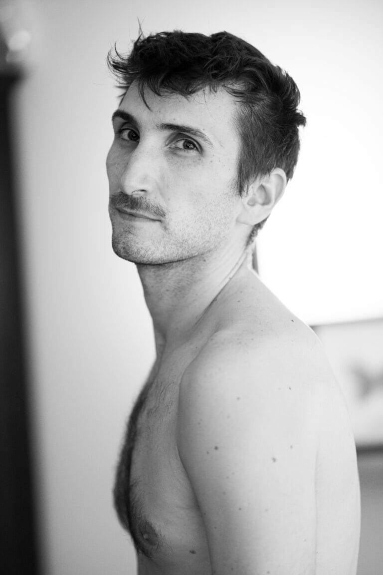 T. torse nu de profil, regard levé, lumière naturelle vive — nu artistique noir et blanc