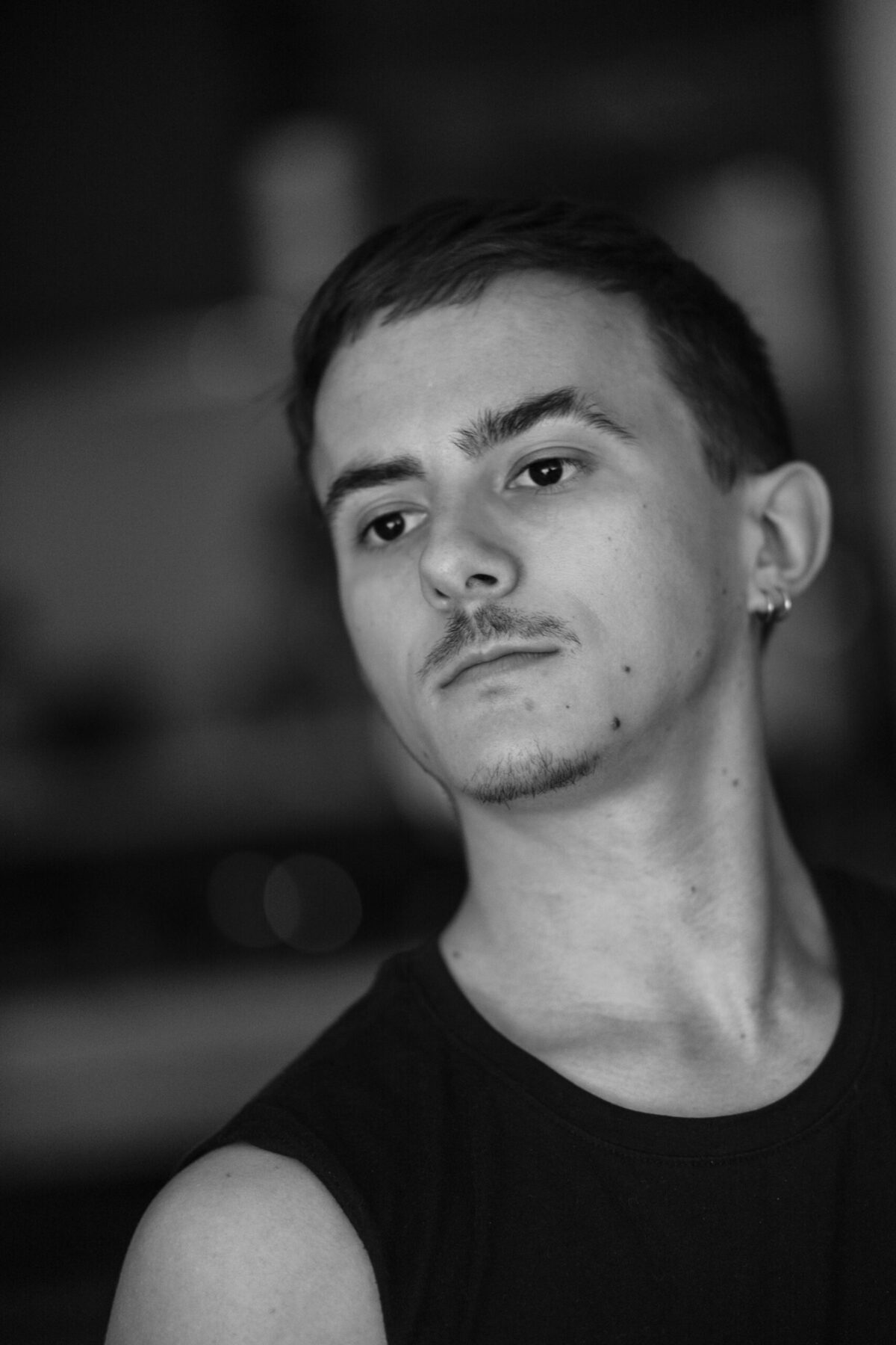 Portrait sombre de Gaston, regard caméra, fond noir — portrait masculin