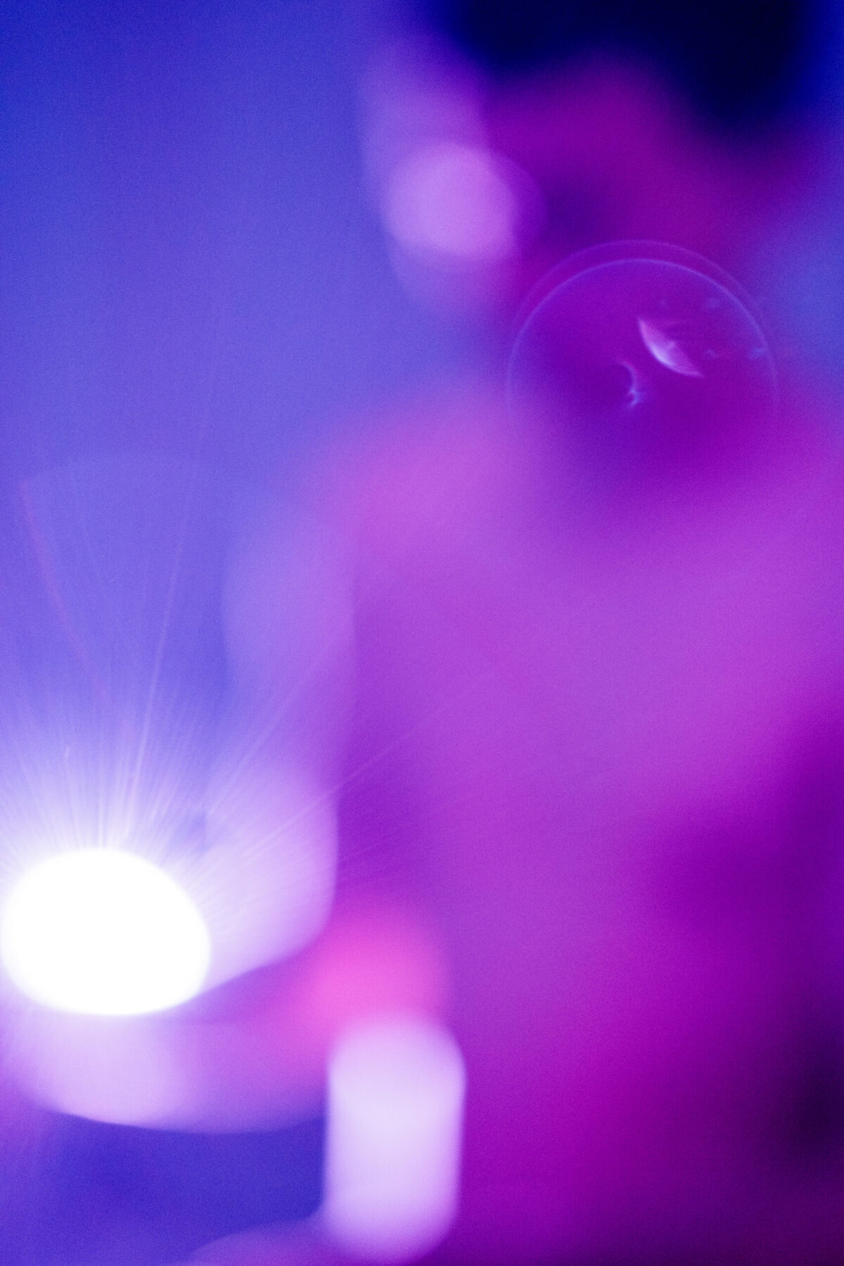 Halos de lumière violette et reflets, ambiance intimiste de la séance — photographie d'atmosphère