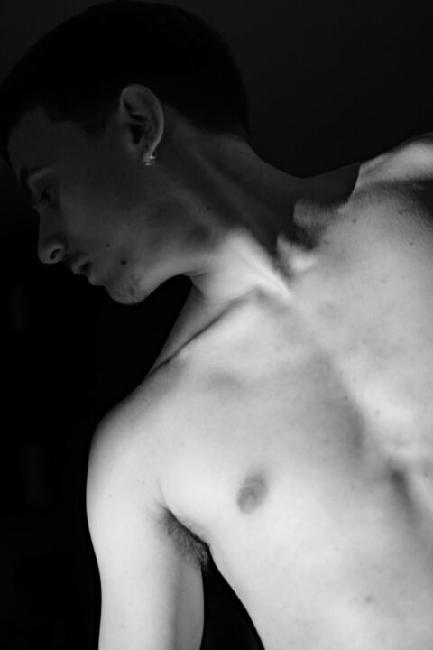 Gaston de profil, épaule nue, regard baissé en noir et blanc — portrait sensible