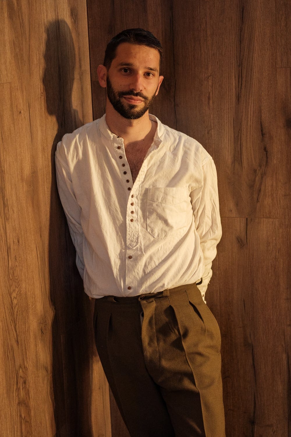 François adossé à un mur de bois, chemise blanche ouverte — portrait masculin