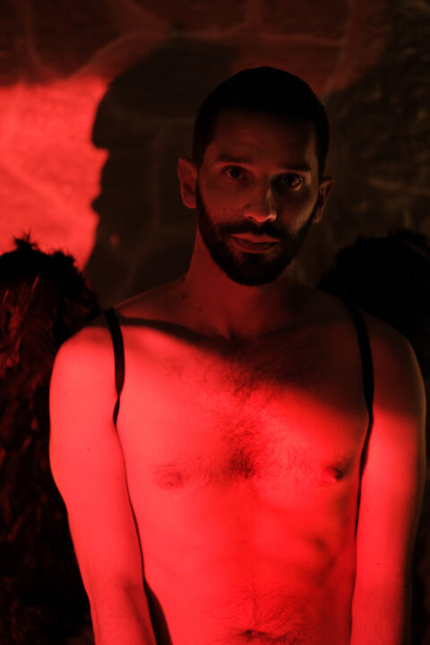 François en cosplay, ange déchu. Ambiance intime rouge et noire.