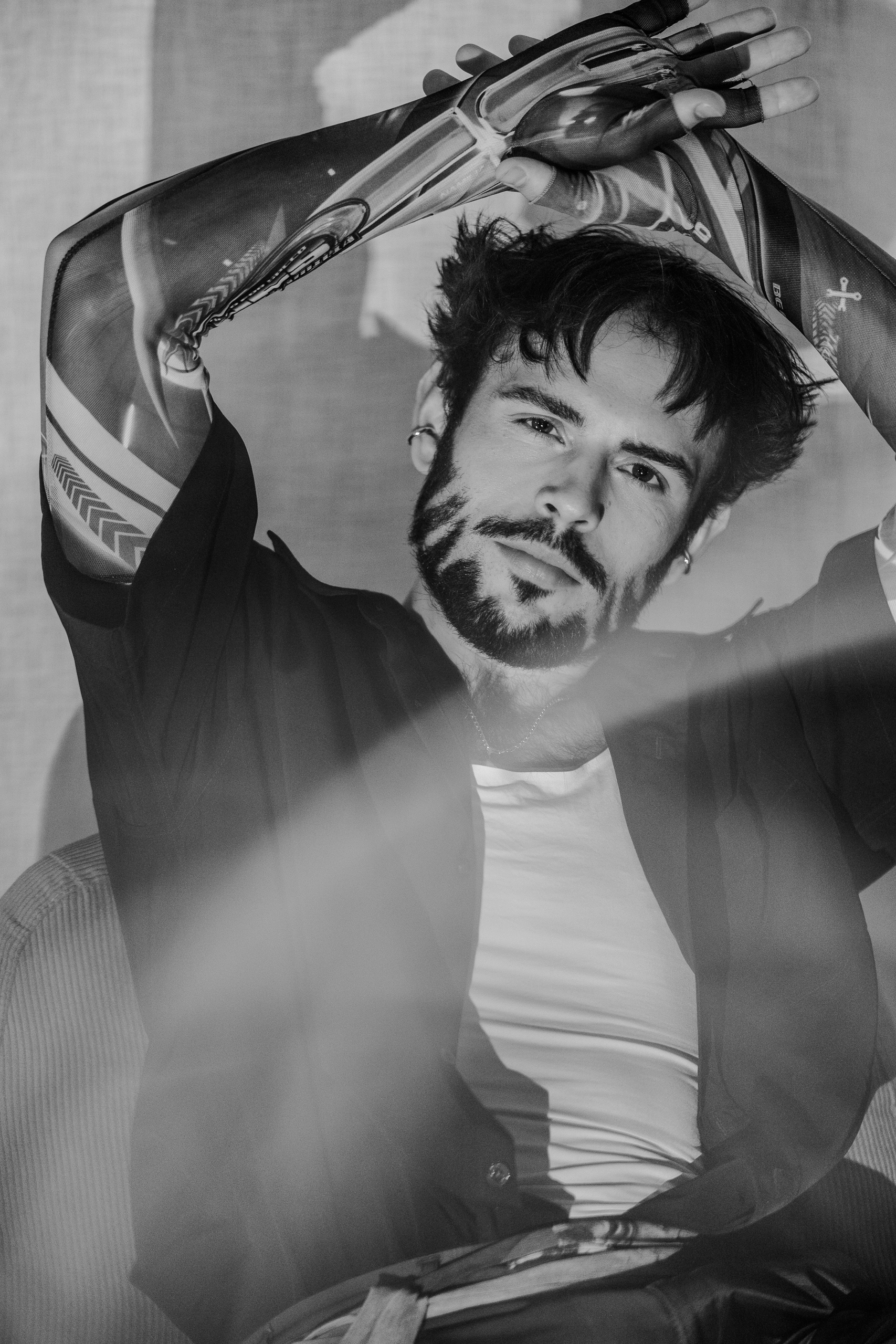 Portrait noir et blanc d'Hugo bras levé au-dessus de la tête, débardeur blanc