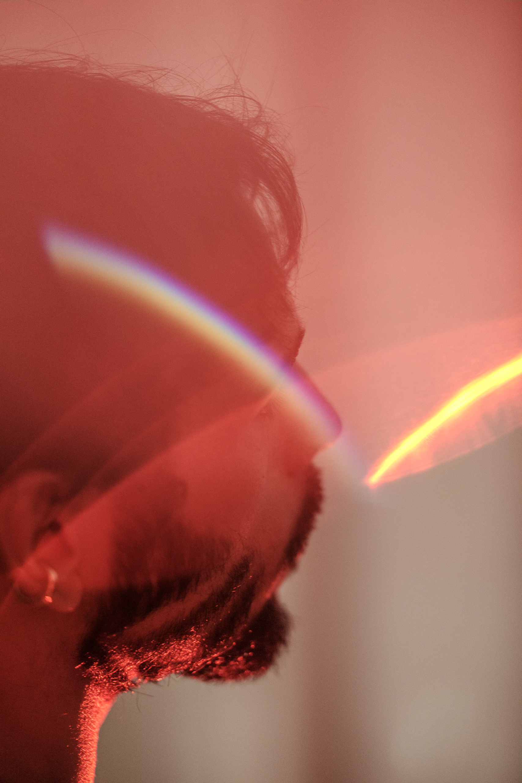 Portrait artistique d'Hugo avec effet de lumière prismatique rouge et doré