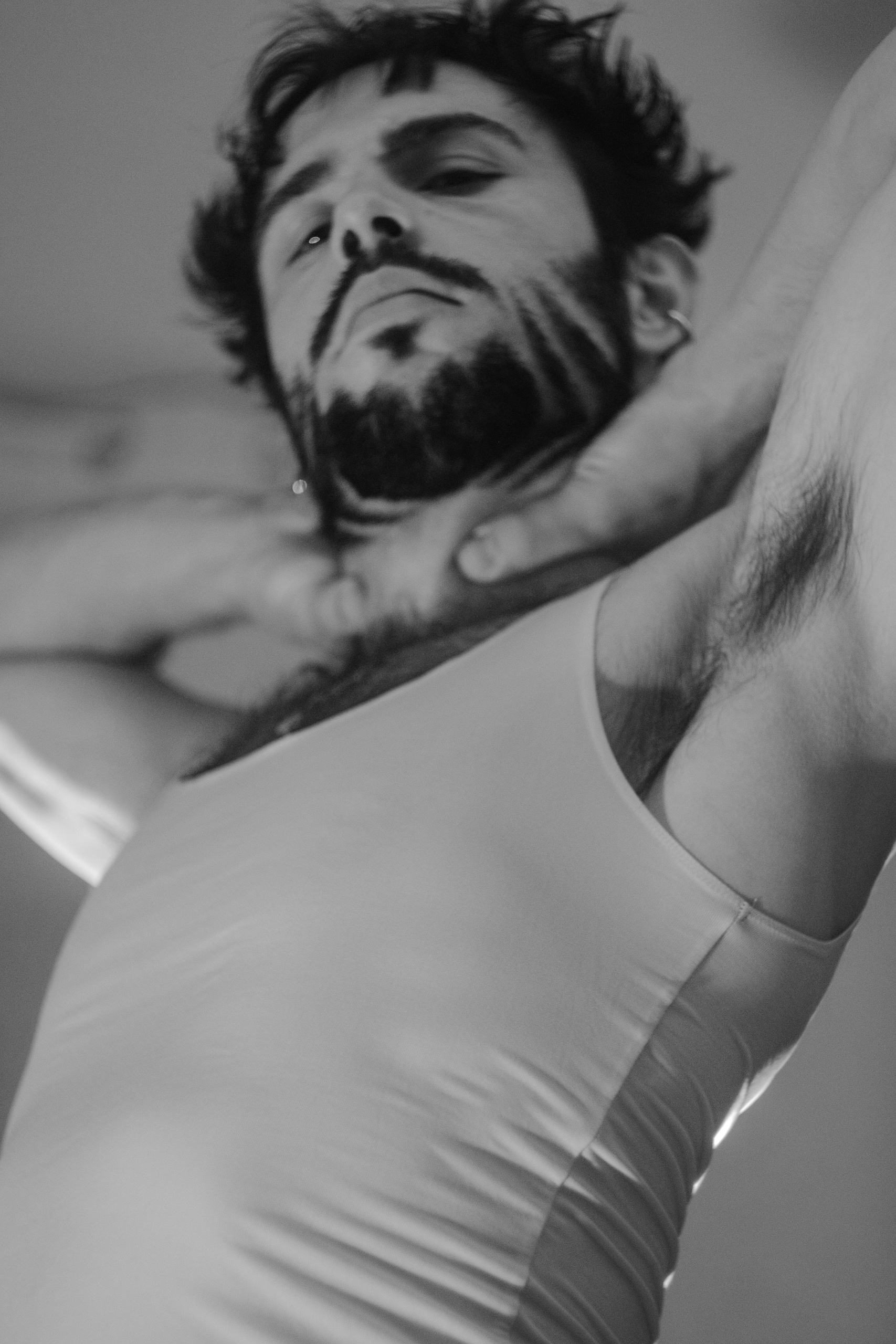 Portrait noir et blanc d'Hugo tête renversée, bras levés, pose épurée