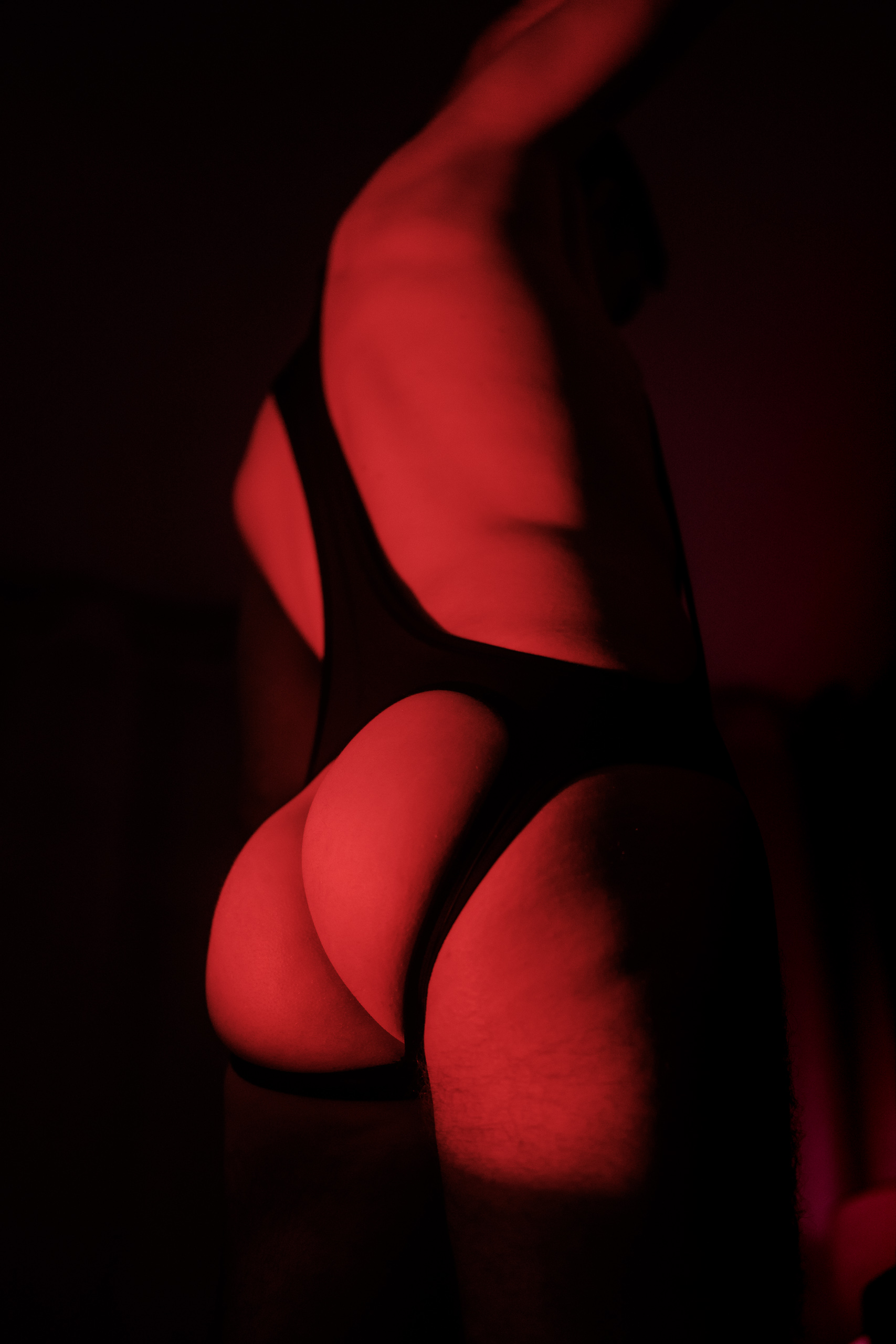 Silhouette de Lionel de dos en contre-jour rouge, nu artistique, jeu d'ombres marqué.