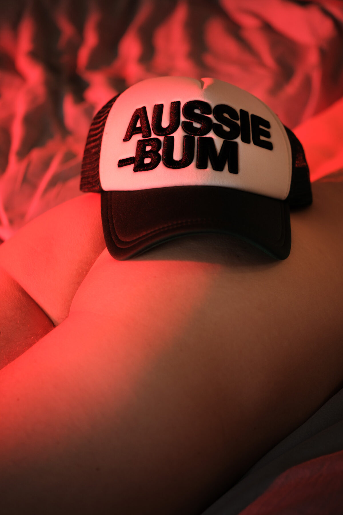 Porträt von Vincent mit australischer Kappe (Aussiebum) im Bett, blaues Licht
