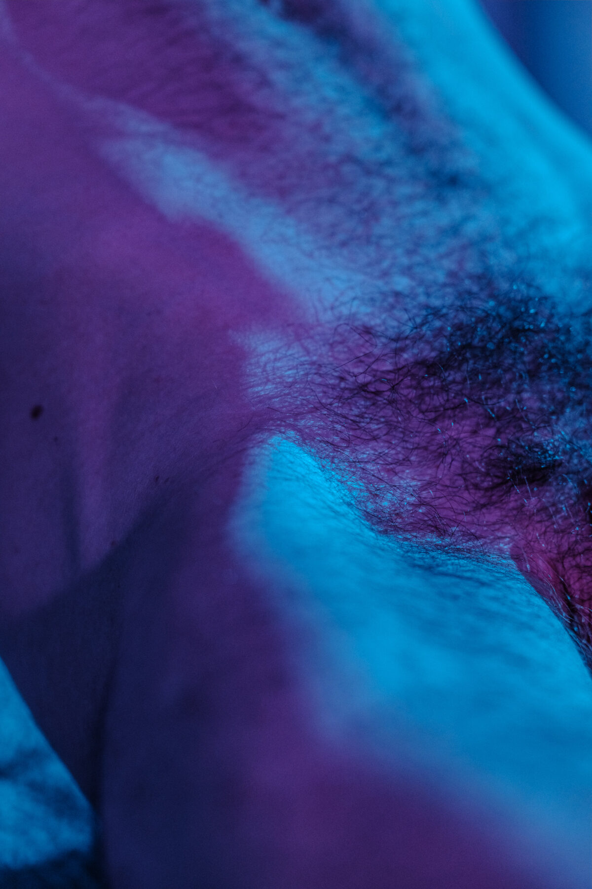 Nahaufnahme von Clements Hüfte, blaue und violette Beleuchtung.