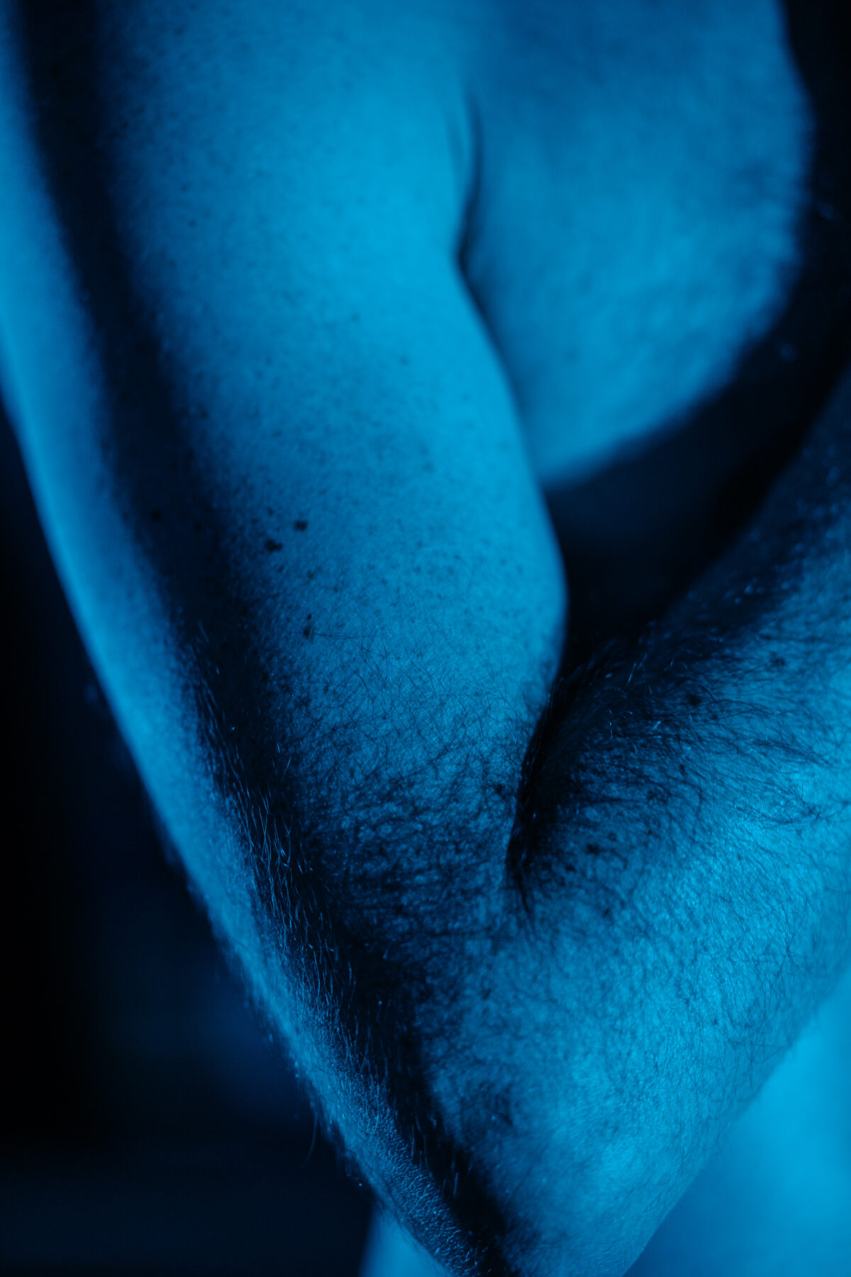 Abstrakte Nahaufnahme von Cléments Beinen, nächtliche blaue Beleuchtung.