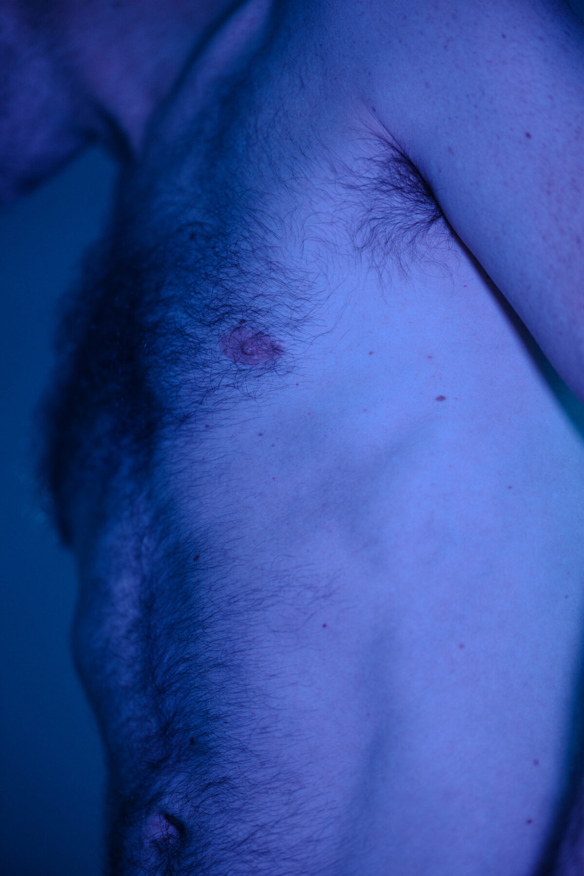 Nahaufnahme von Clements Oberkörper, blaue und violette Beleuchtung.