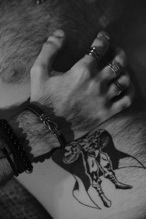 Gros plan sur des mains et un tatouage d'avant-bras, noir et blanc.
