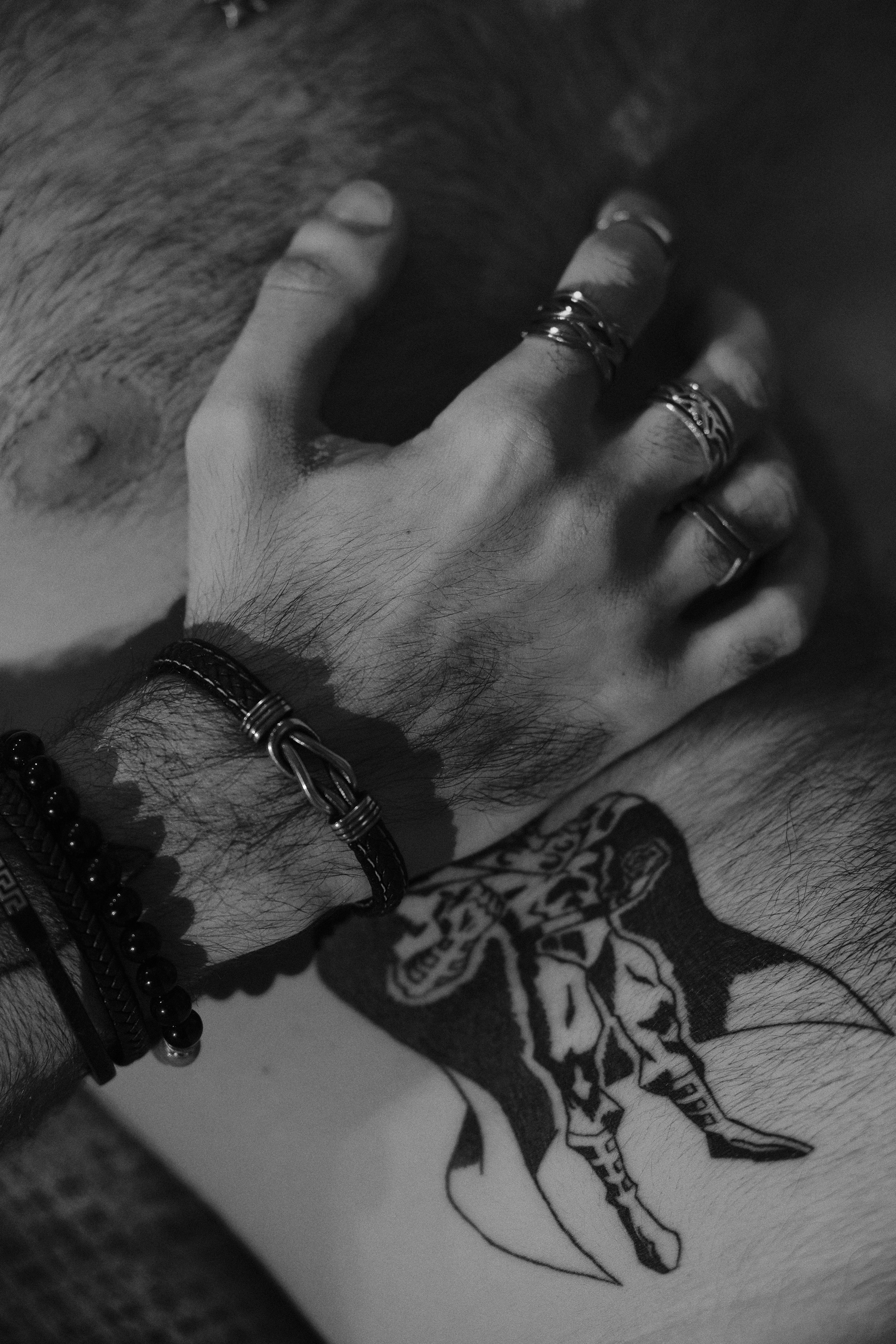 Gros plan sur des mains et un tatouage d'avant-bras, noir et blanc.