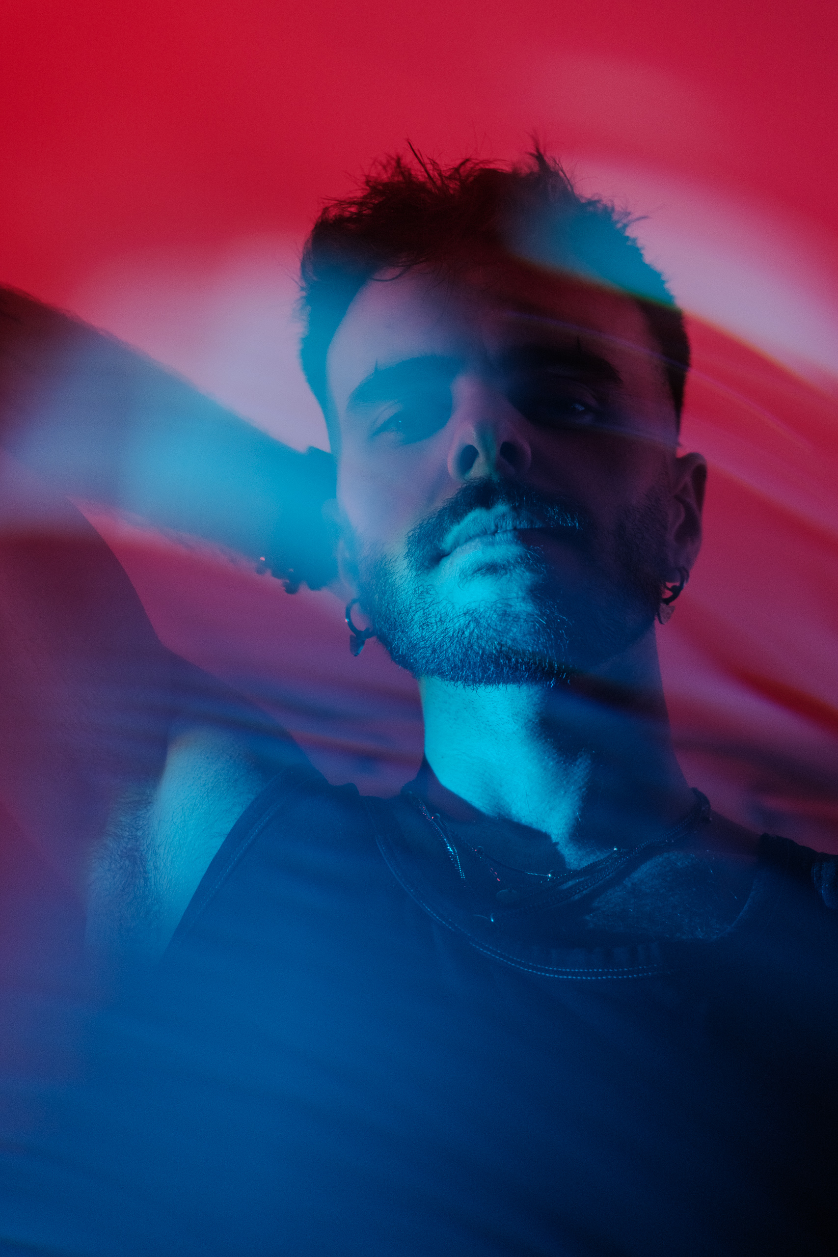 Portrait flou artistique, effet de mouvement lumineux bleu et rouge.