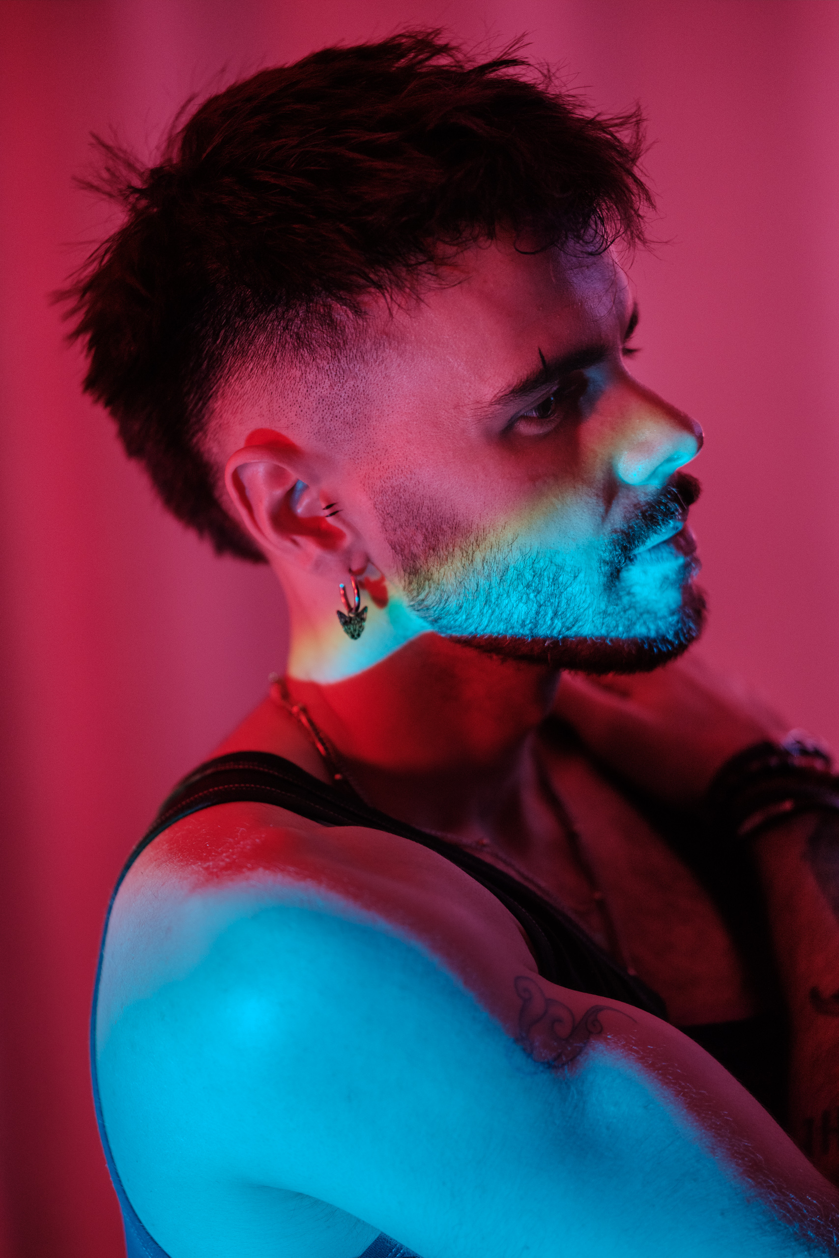 Portrait de profil, bracelets et boucle d'oreille, éclairage rose.