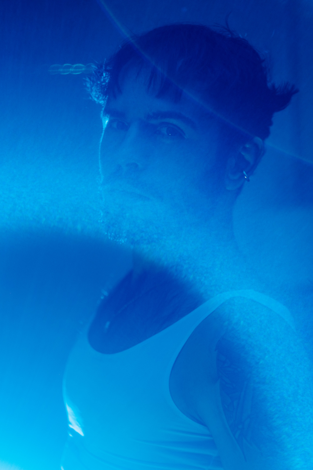 Hugo, portrait masculin flouté en lumière bleue, effet de mouvement, débardeur blanc