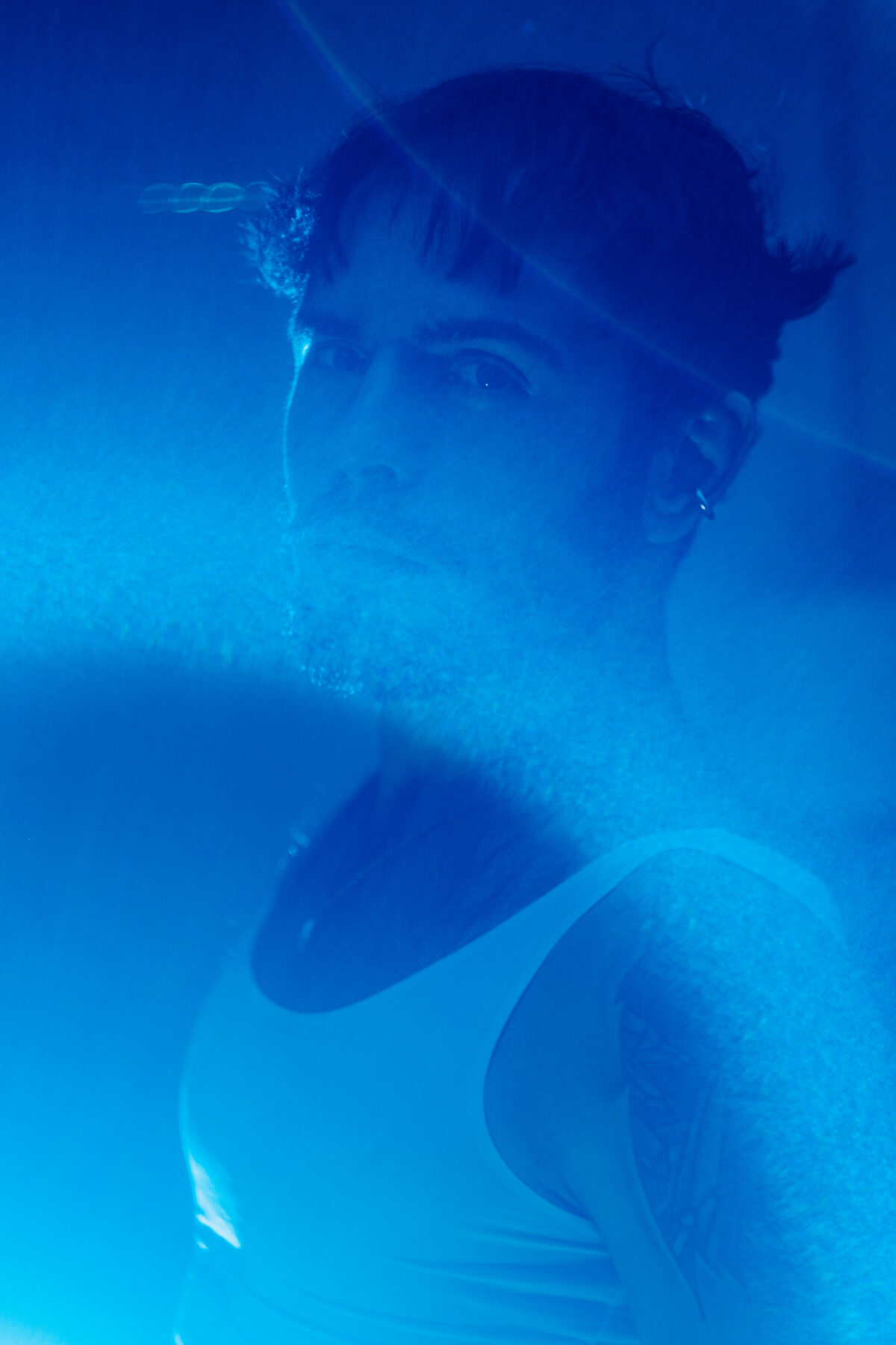 Hugo, portrait masculin flouté en lumière bleue, effet de mouvement, débardeur blanc