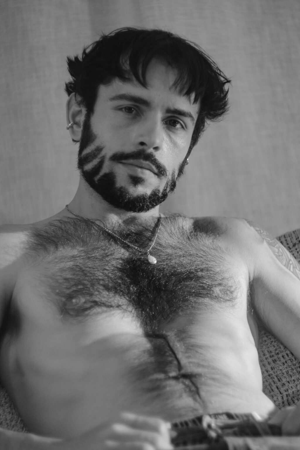Portrait torse nu d'Hugo, chaîne et pendentif, regard caméra en noir et blanc
