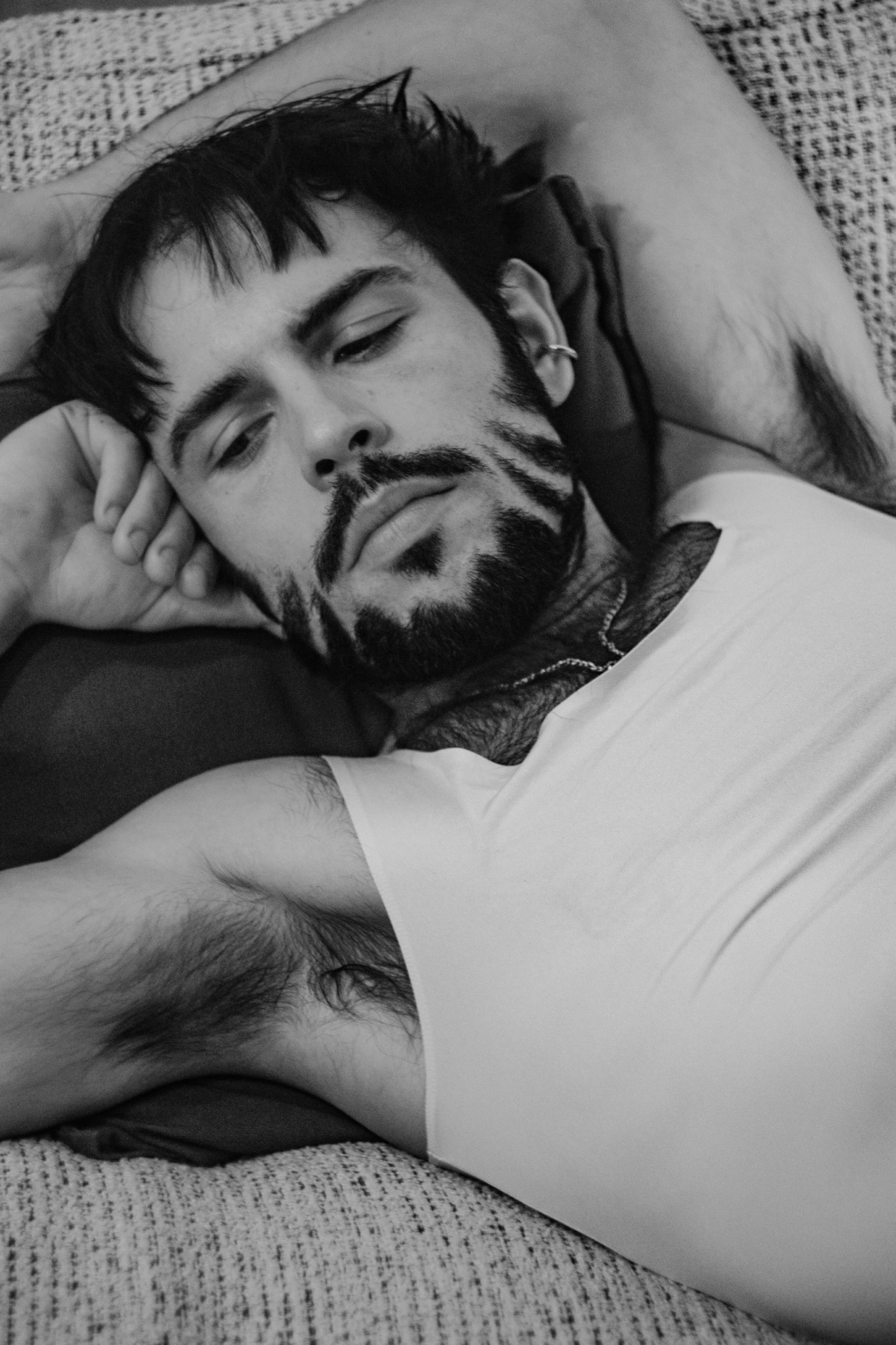Hugo allongé en noir et blanc, yeux mi-clos, ambiance calme et posée