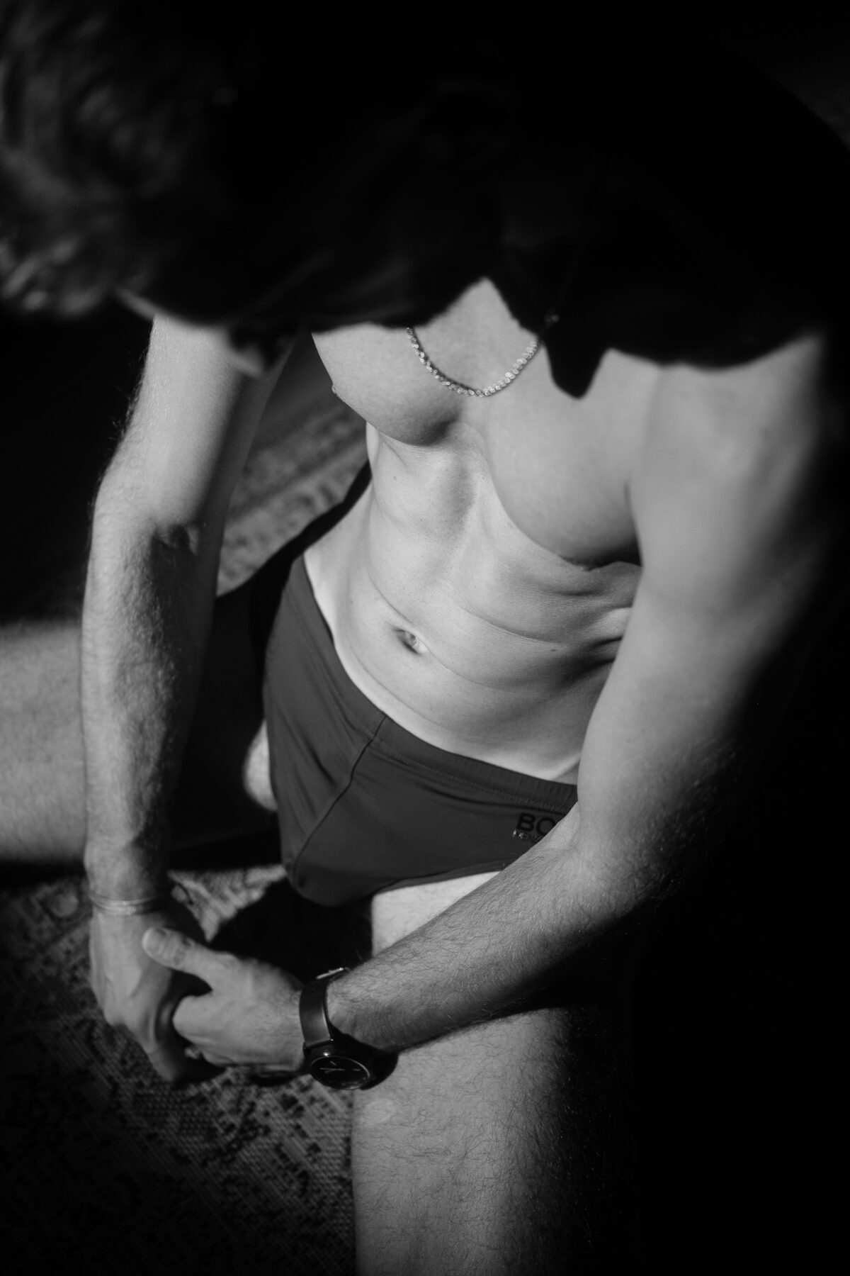 Portrait noir et blanc de Loukas More en boxer, cadrage rapproché, photographie artistique masculine.