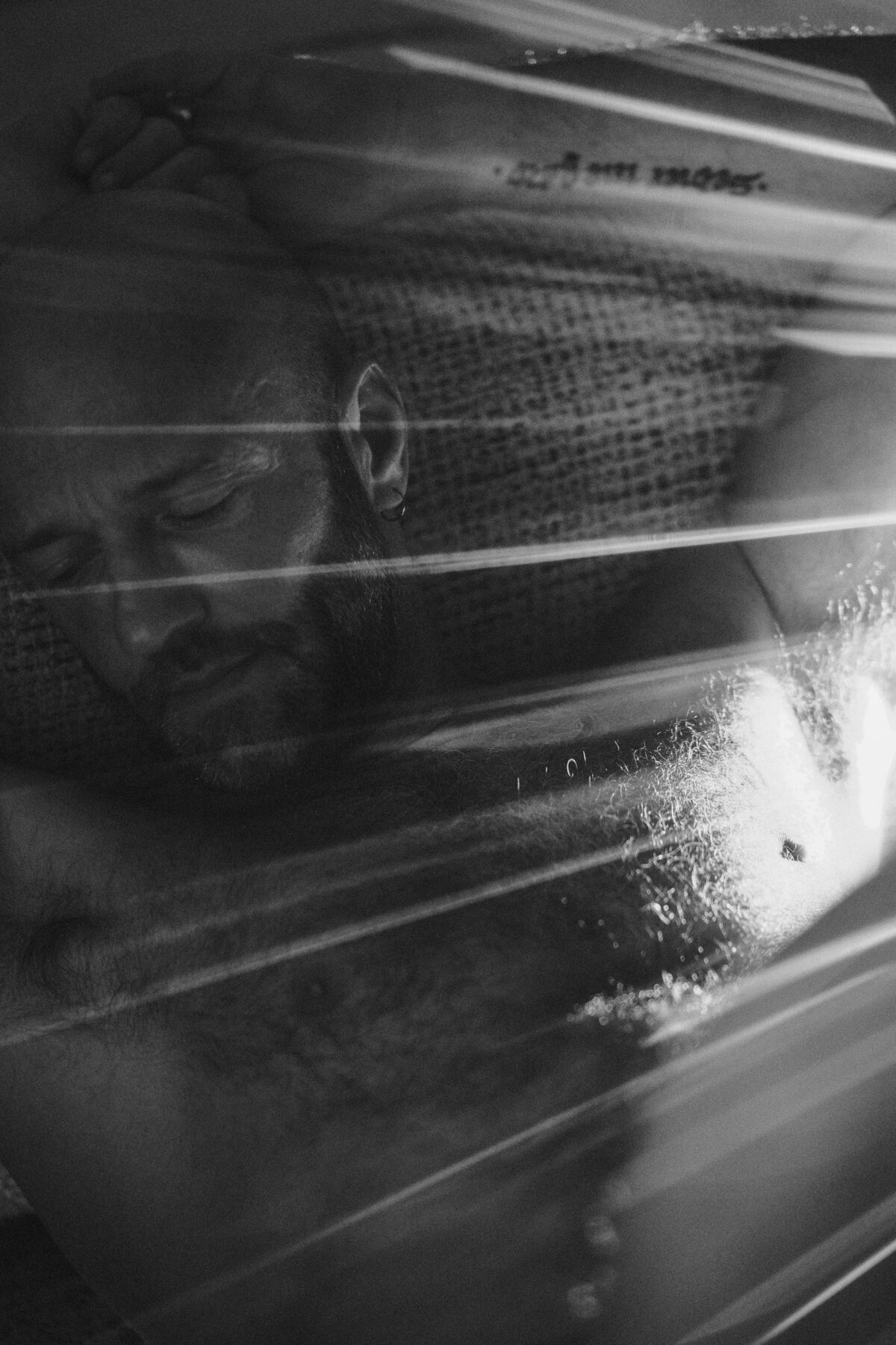 Portrait de profil de Benoit voilé de lignes de lumière, clair-obscur sur le visage et l'épaule
