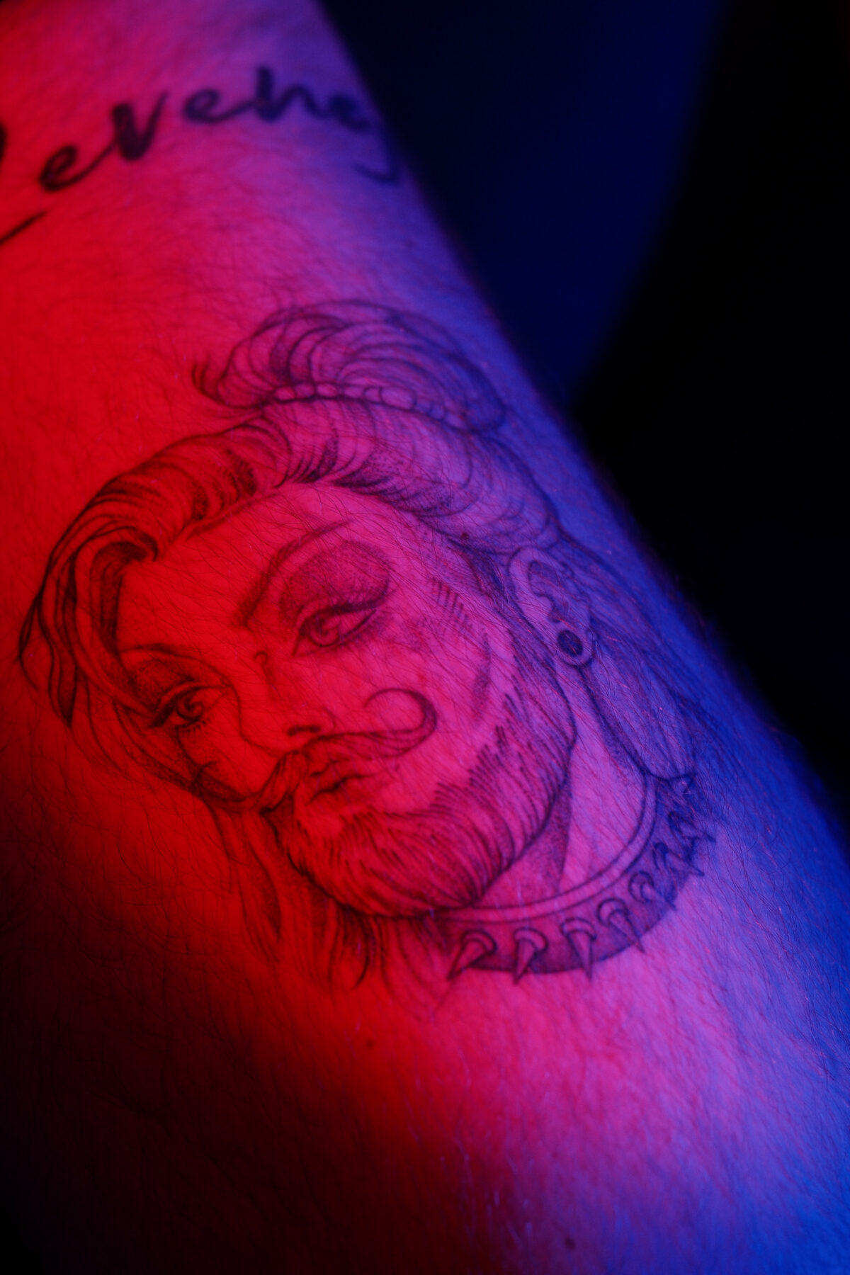 Gros plan sur le tatouage de François, portrait encré sur l'avant-bras et inscription Revenge
