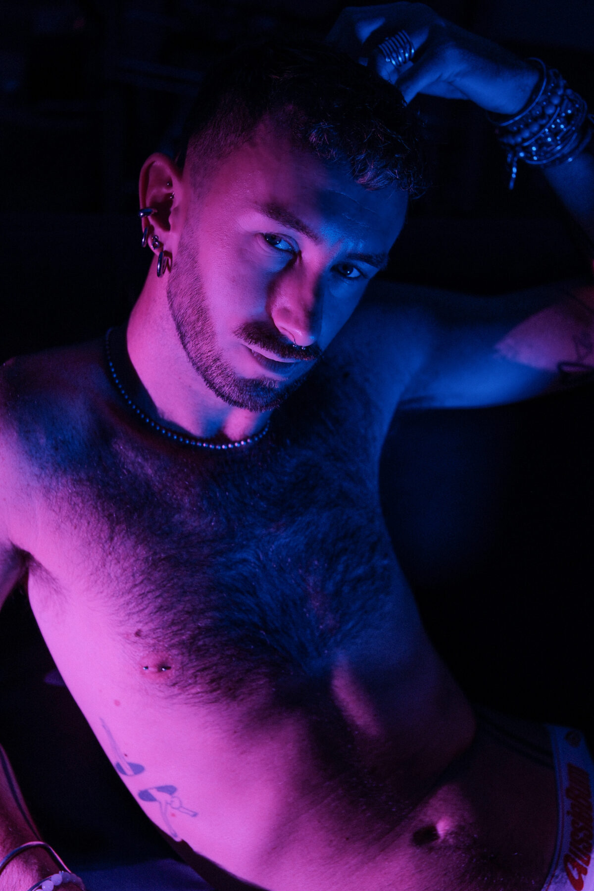 Portrait de Hugo (de Lille), éclairage bicolore rose et bleu, bracelets, bagues, piercings, collier