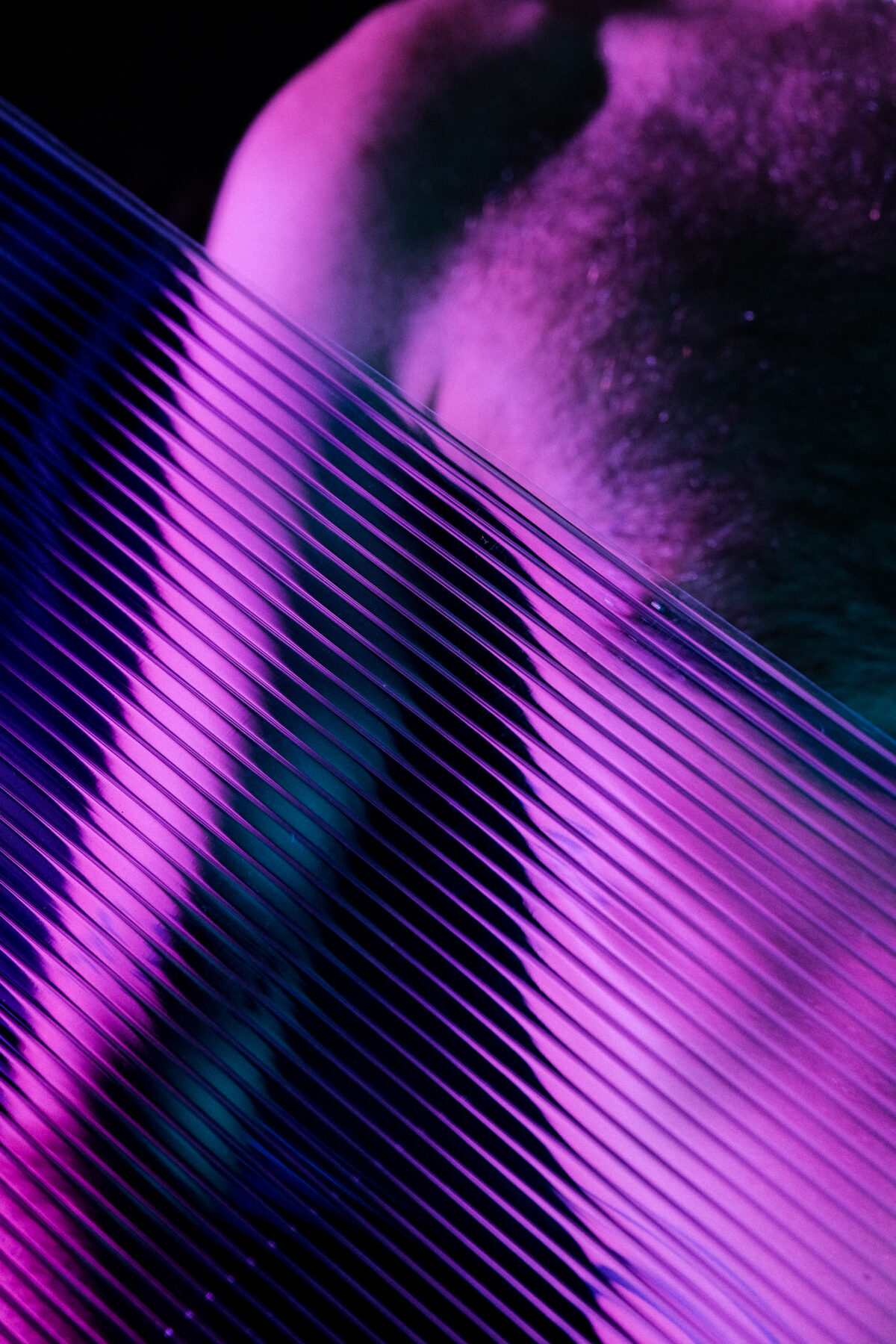 Gros plan abstrait sur le torse de Hugo (de Lille), effet de matière striée, éclairage violet et turquoise
