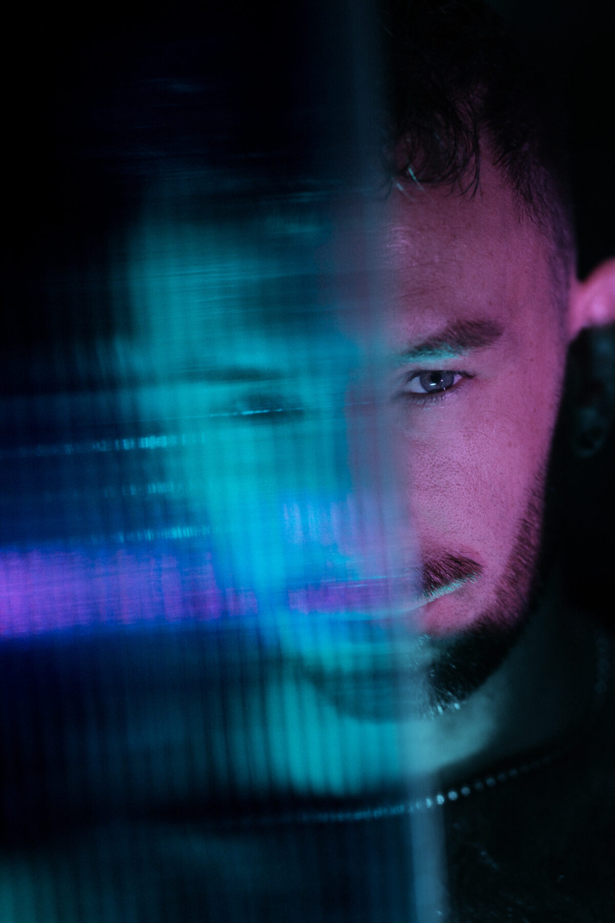 Portrait rapproché de Hugo (de Lille), effet de flou artistique, éclairage bicolore bleu et rose