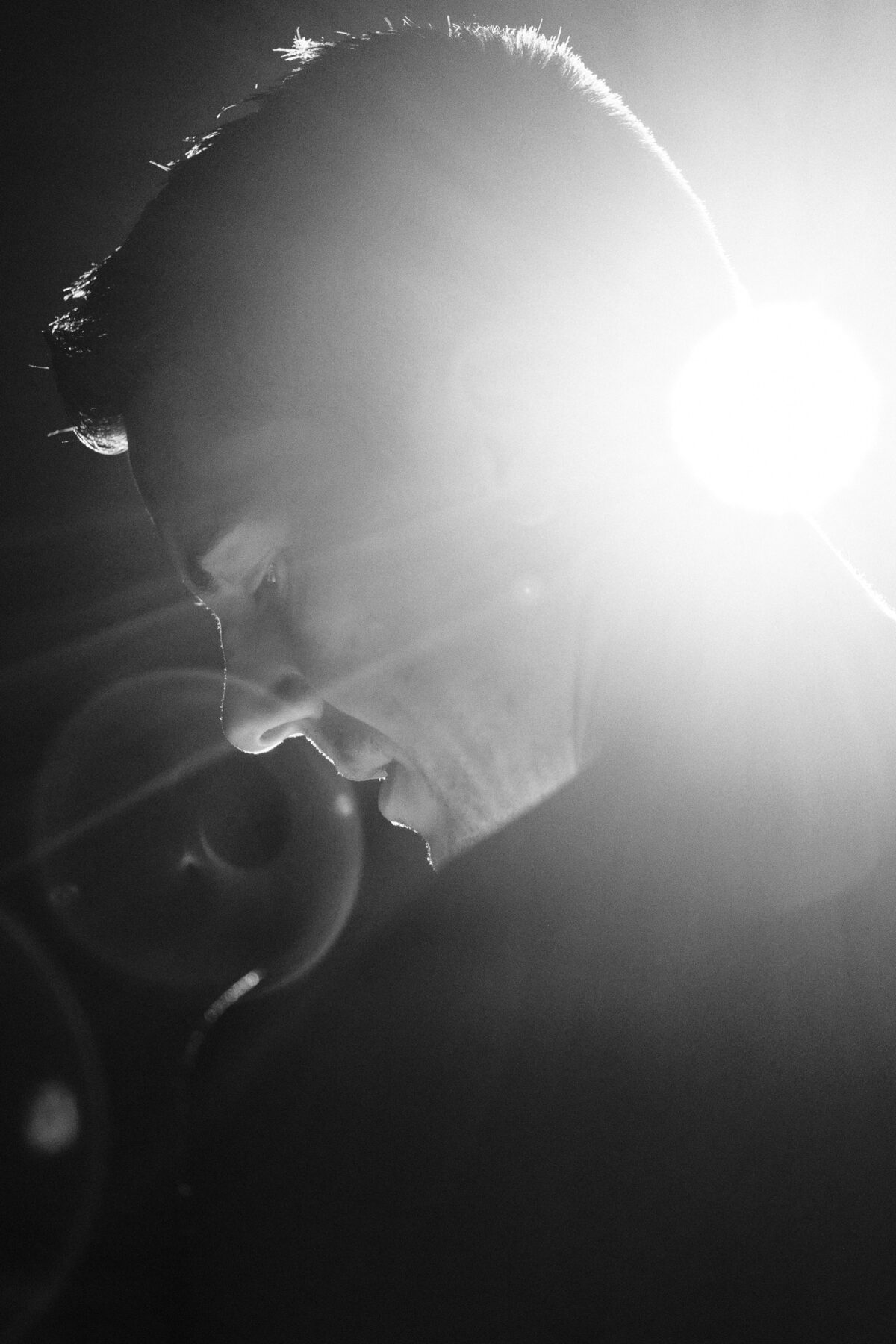 Silhouette noir et blanc d'un profil masculin à contre-jour, forte lumière en arrière-plan, photographie artistique graphique