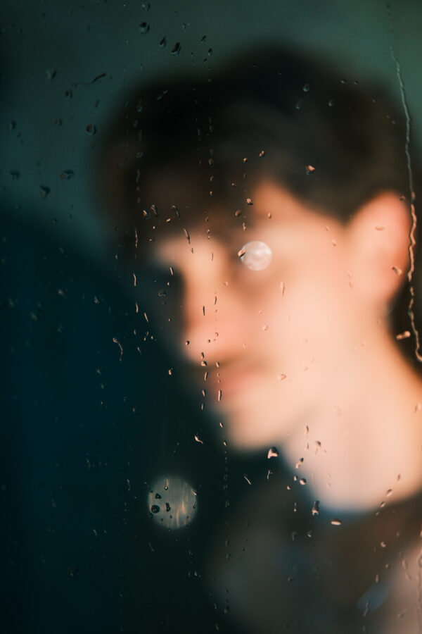Portrait de Nico flou à travers une vitre embuée, effet artistique, éclairage chaud