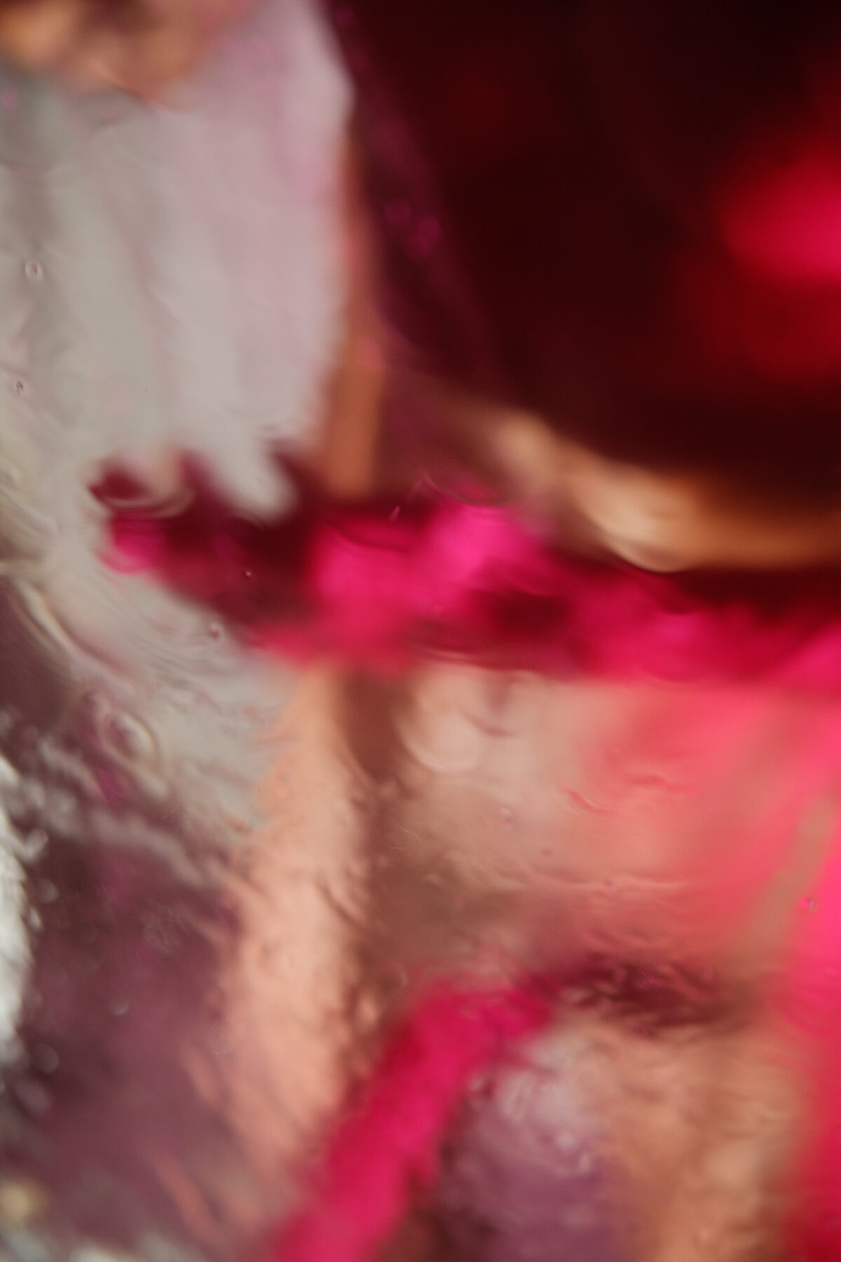 Gros plan abstrait sur la peau d'un homme, jeu de lumière rose et rouge, photographie artistique
