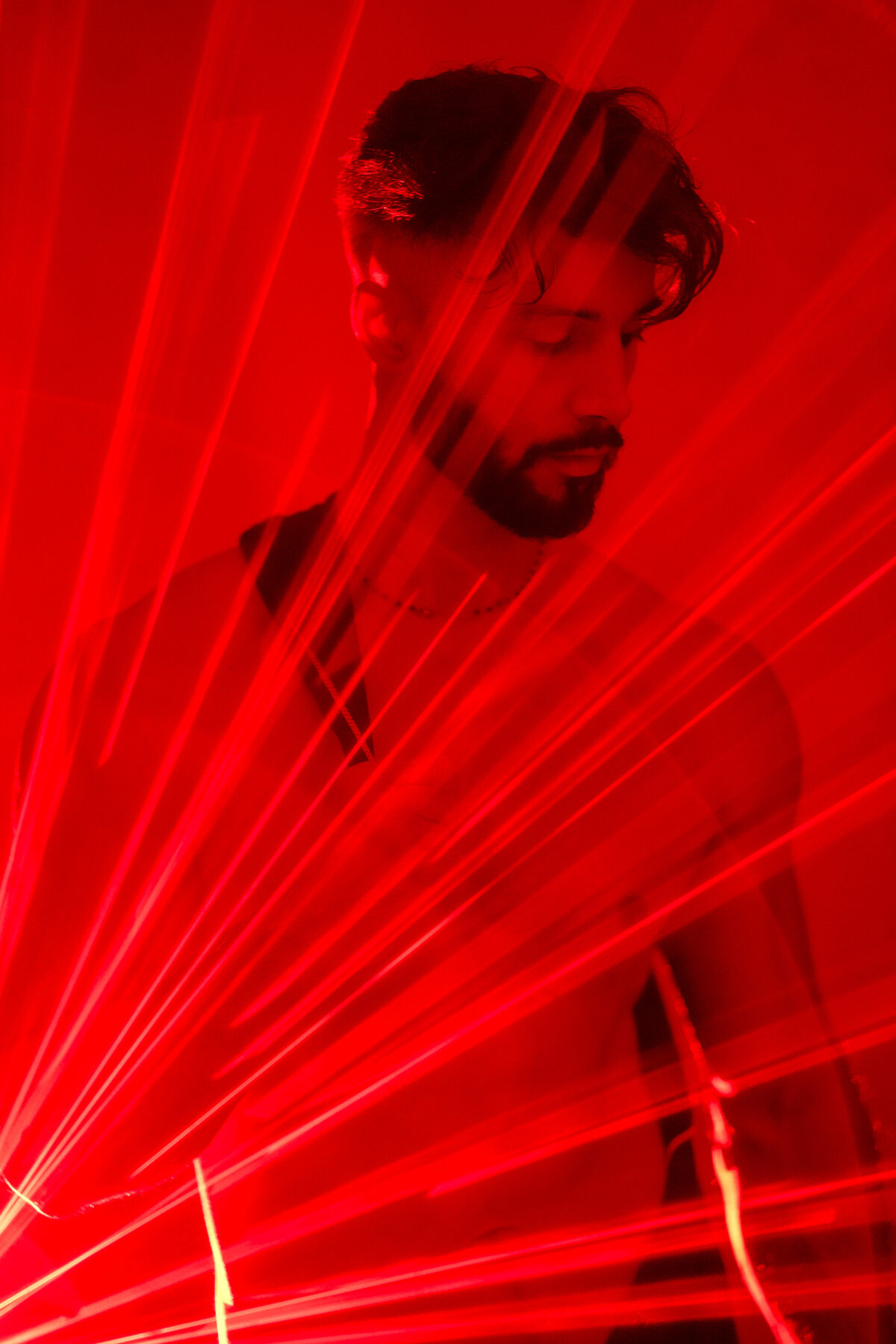 Visage d'Andy à travers des faisceaux laser rouges